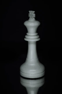 a white chess piece sitting on top of a table