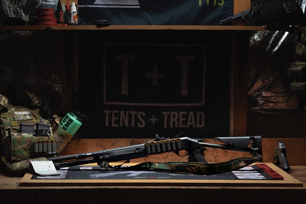 a gun and rifle on a table in a room