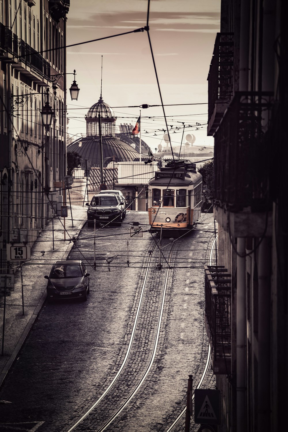 a train traveling down tracks next to a tall building