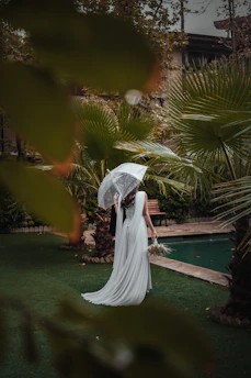 a bride and groom standing under an umbrella