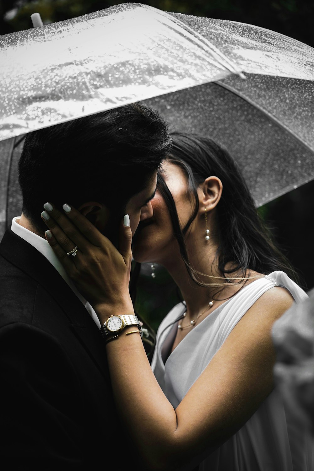 a bride and groom kissing under an umbrella
