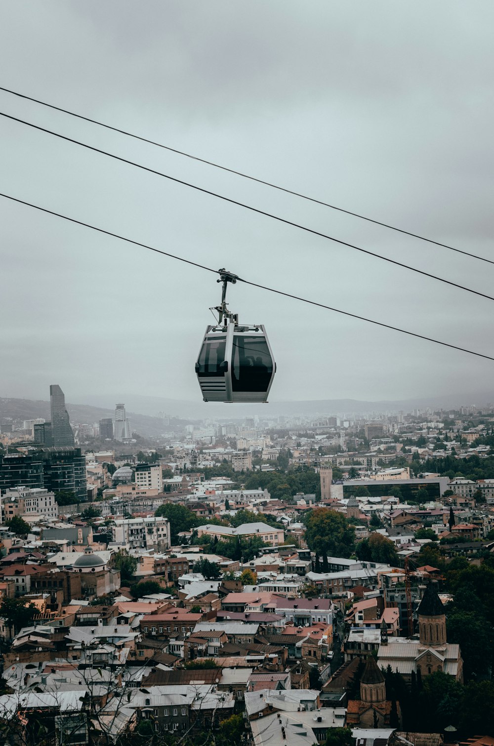 a cable car going over a city in the sky