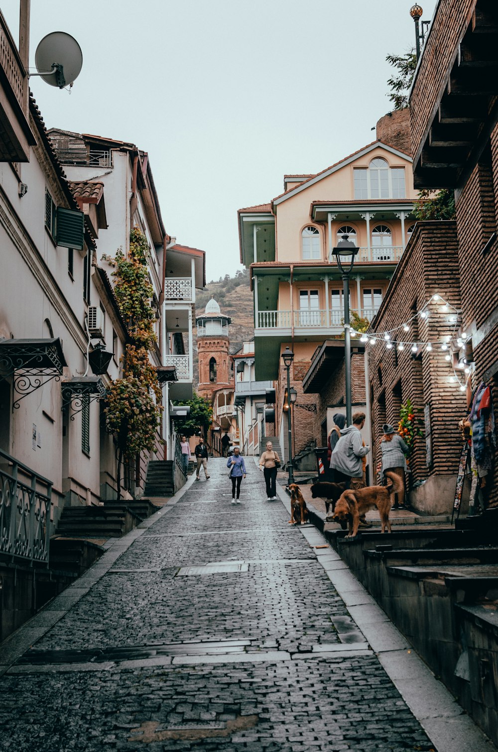 a couple of people walking down a cobblestone street