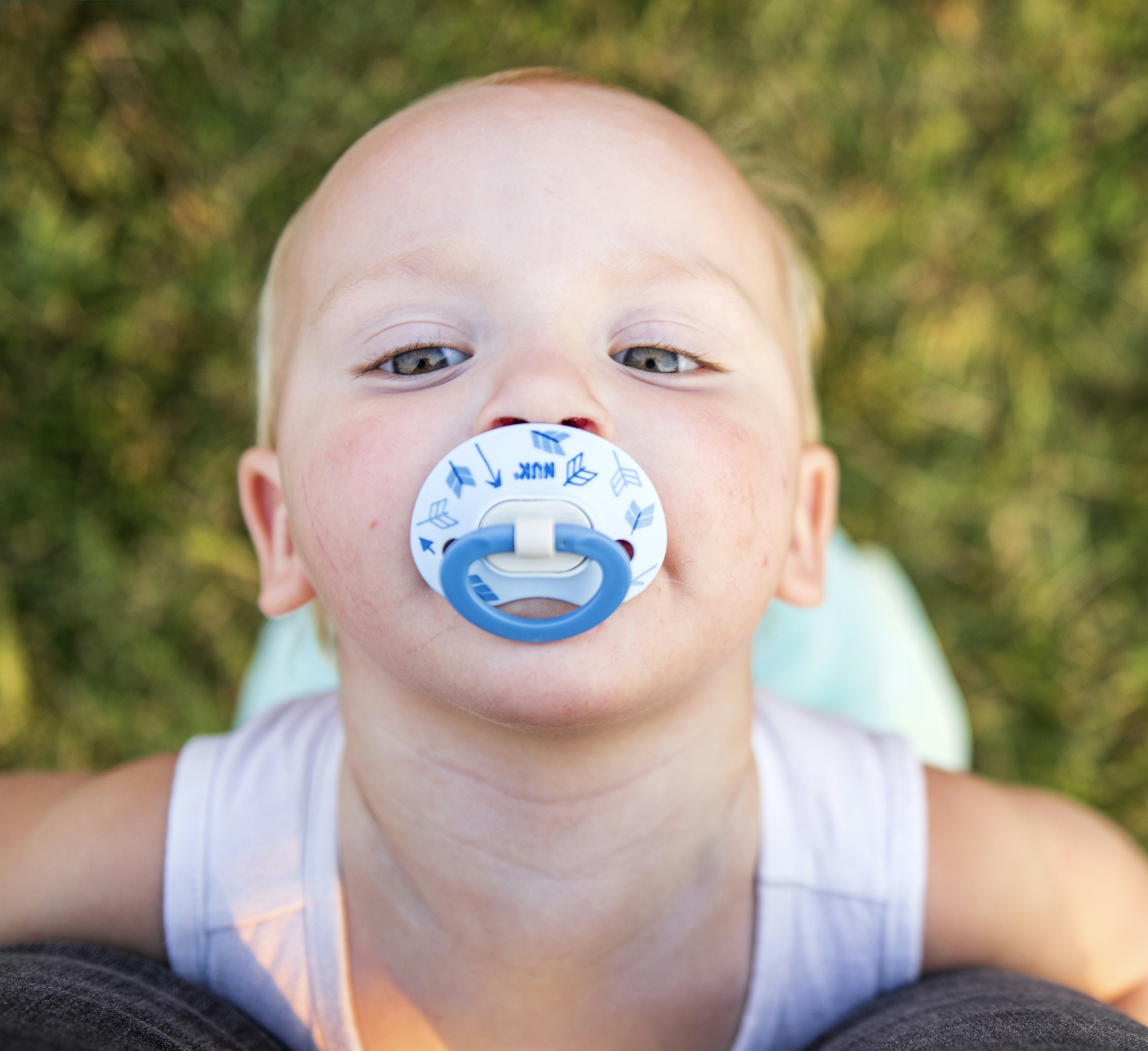A young boy with a pacifier in his mouth photo Free Symbol Image on