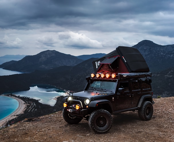 a jeep with a tent on top of a hill