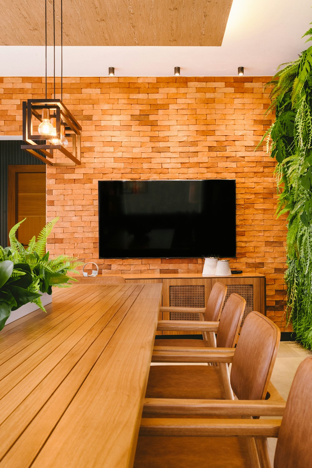 a wooden table and chairs in front of a flat screen tv