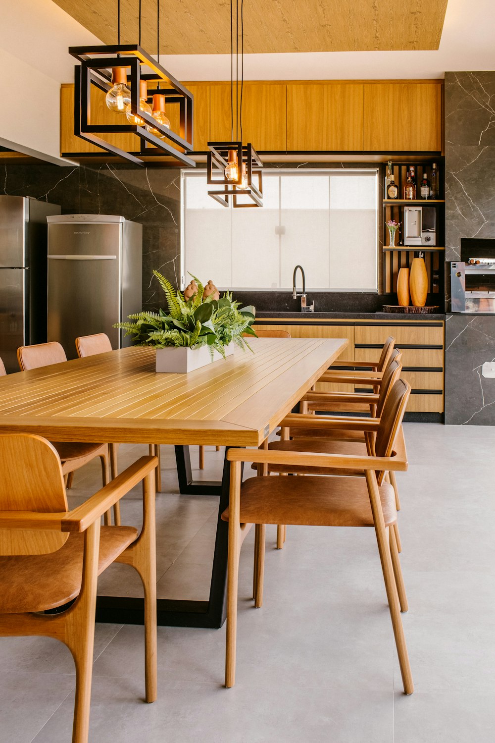 uma cozinha com armários de madeira e uma mesa de jantar
