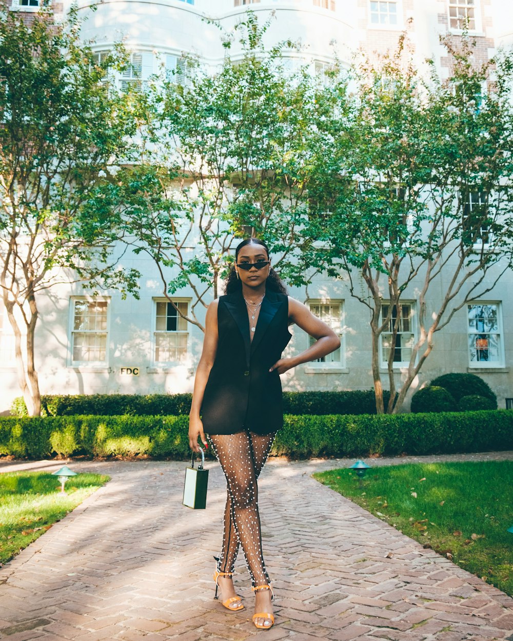 a woman in tights and heels standing in front of a building