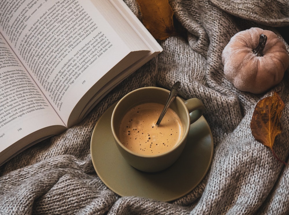 a cup of coffee and a book on a blanket