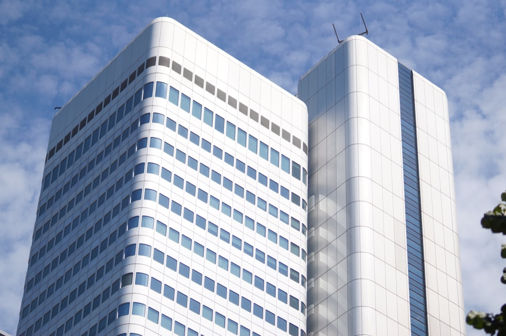 a tall white building sitting next to a tree