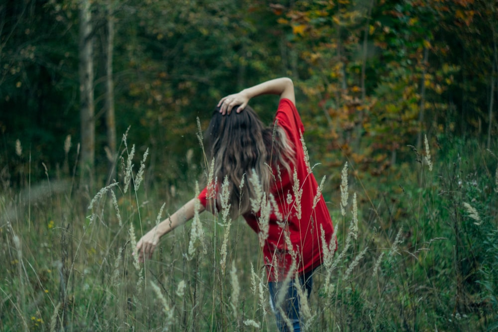 a woman standing in a field of tall grass