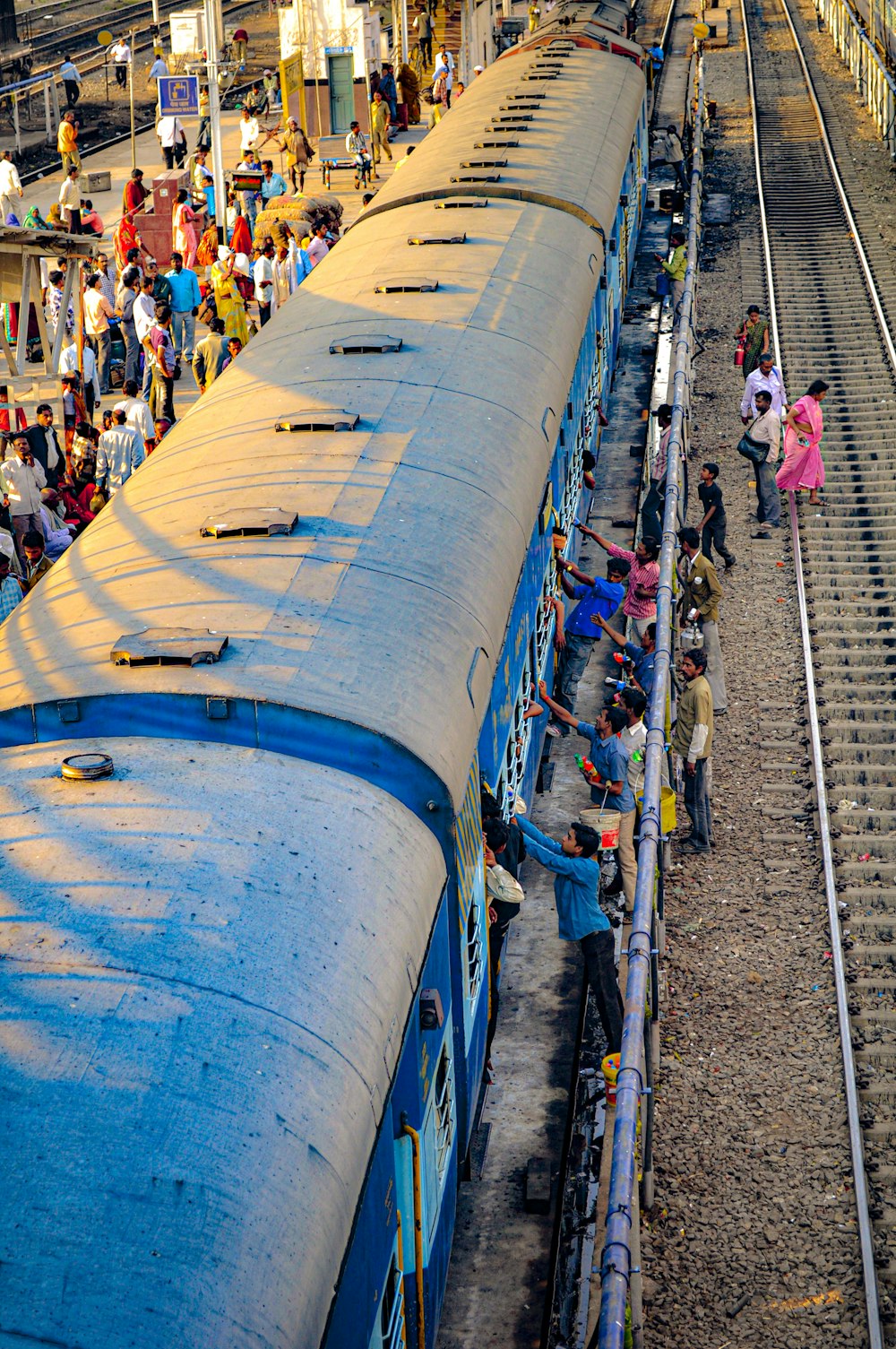 a group of people standing on the side of a train