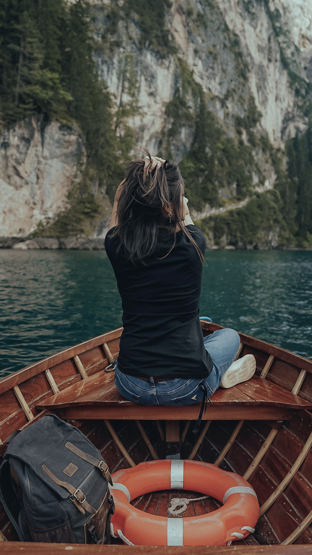 a woman sitting in a boat on a lake