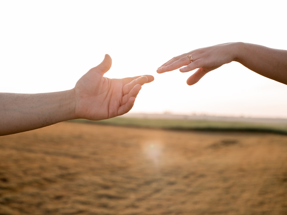 duas mãos estendendo-se uma em direção à outra