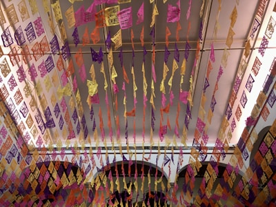 Rows of artisanal piñatas hanging against a backdrop of festive papel picado banners.