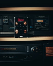 An old-school audio tape deck and VHS player setup is centered in this image. A cassette tape featuring an album cover with four faces and the text 'Bone' and 'Crossroads' is prominently placed in front of the tape deck.