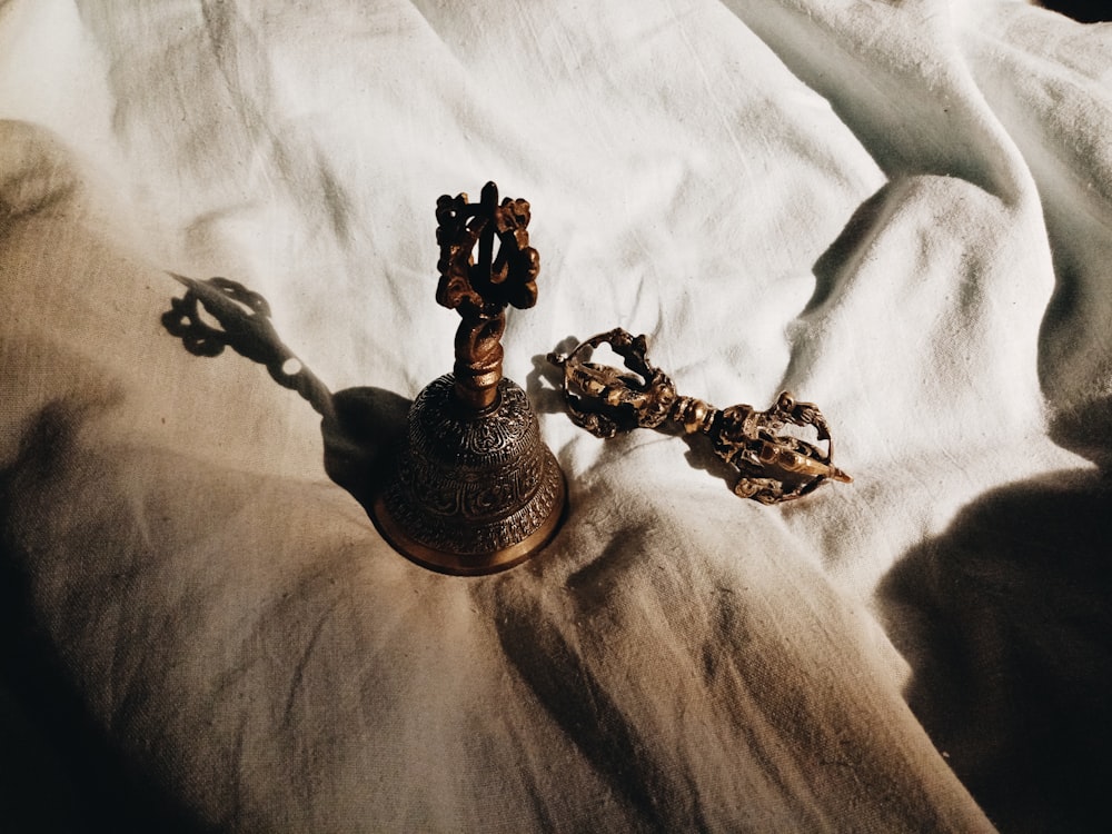 a brown vase sitting on top of a bed next to a chain
