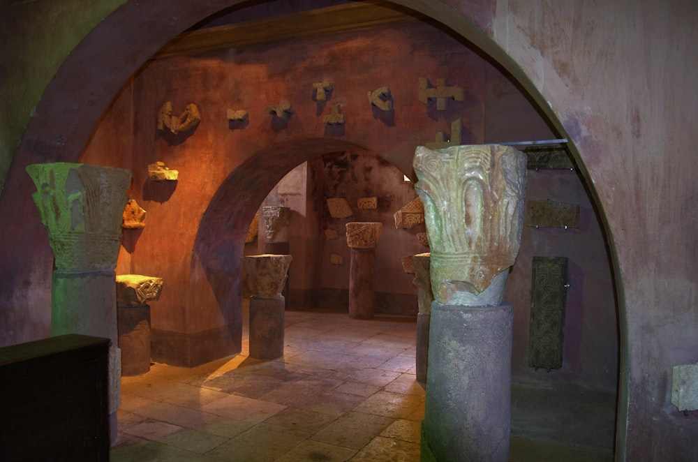a tunnel in a museum with statues and crosses on the walls