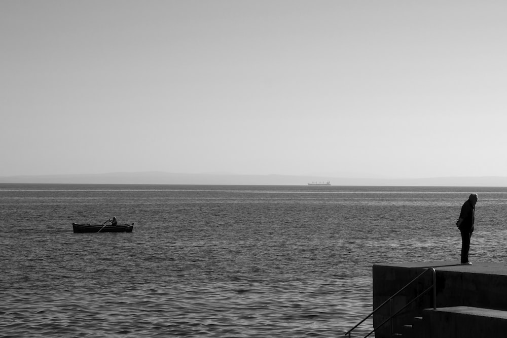 Un uomo in piedi su un molo che guarda l'oceano