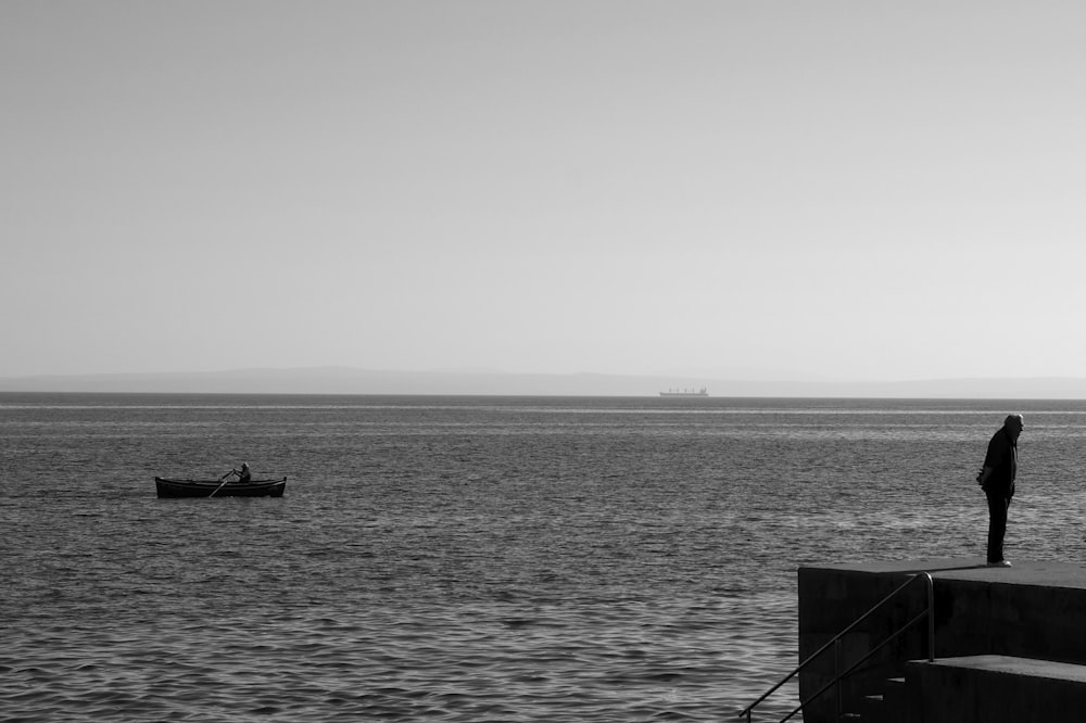 a man standing on a dock looking out at the ocean