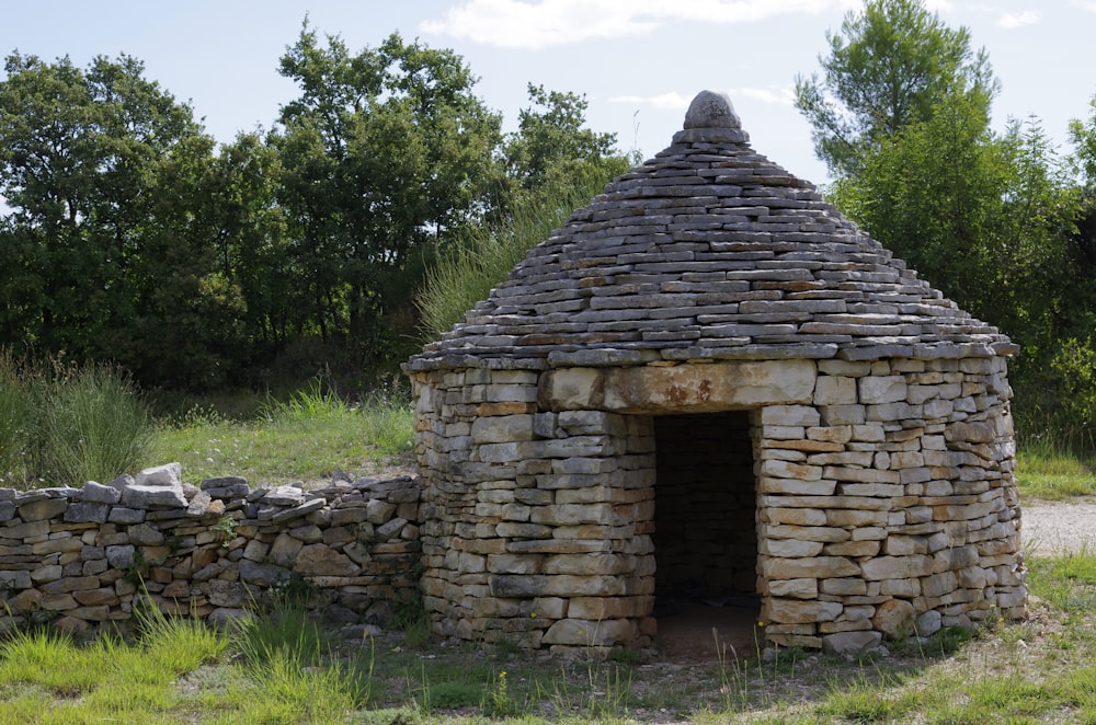 a stone building with a door in the middle of a field