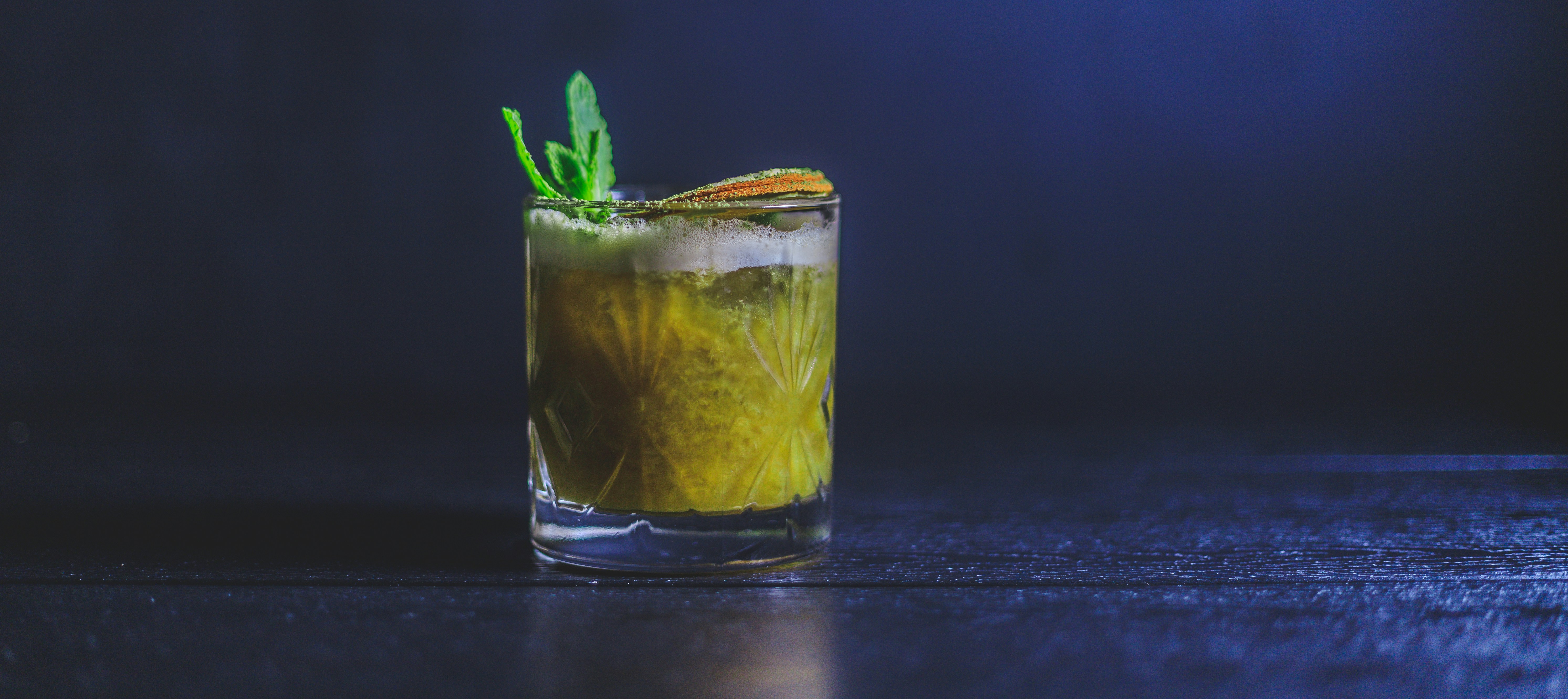 a glass filled with a drink on top of a table