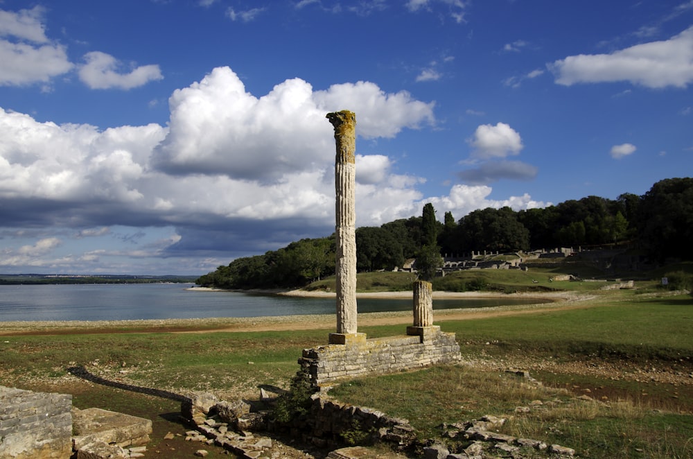 a stone pillar sitting in the middle of a field