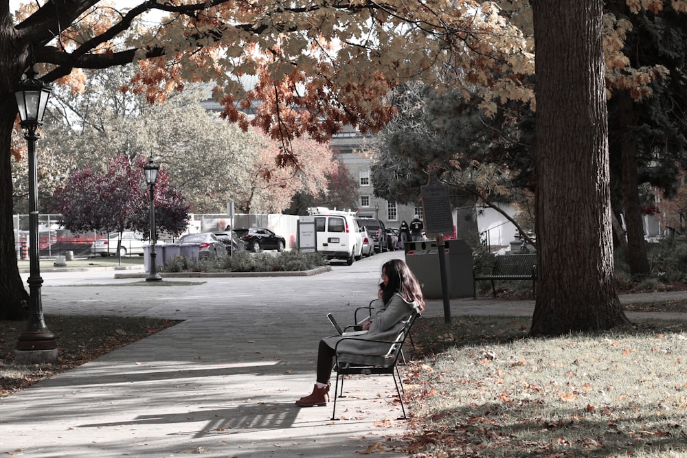 a woman sitting in a chair on a sidewalk