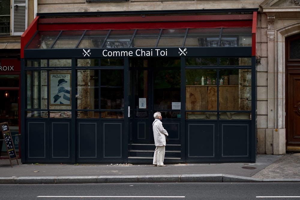 a person standing on a sidewalk in front of a building