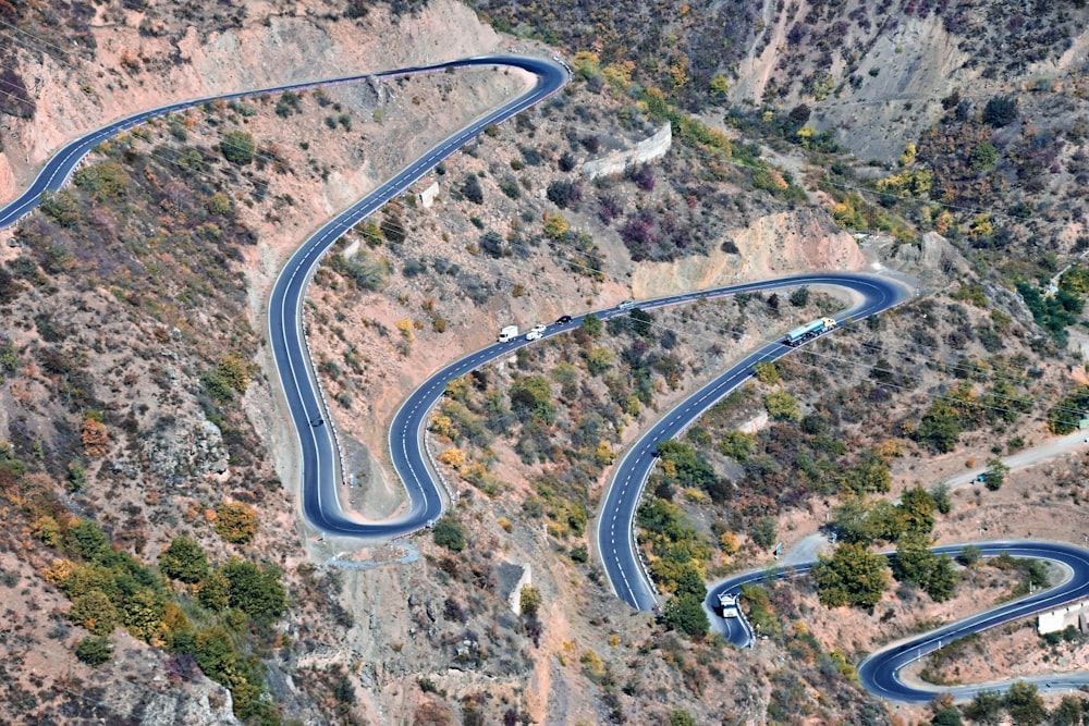 an aerial view of a winding road in the mountains