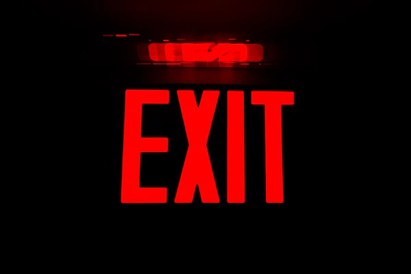 Illuminated red exit sign in a dark corridor