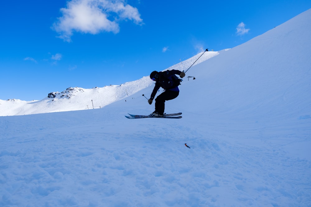 a man riding skis down a snow covered slope