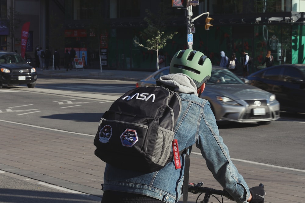 a man riding a bike down a street next to a traffic light