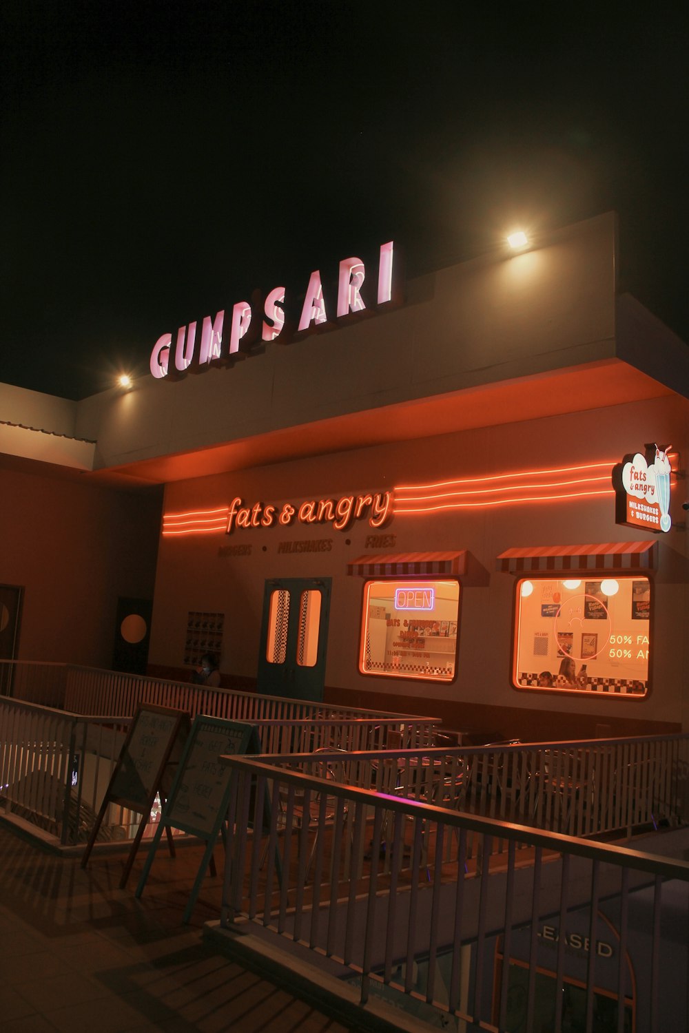 um restaurante chamado gunsari à noite com luzes de néon