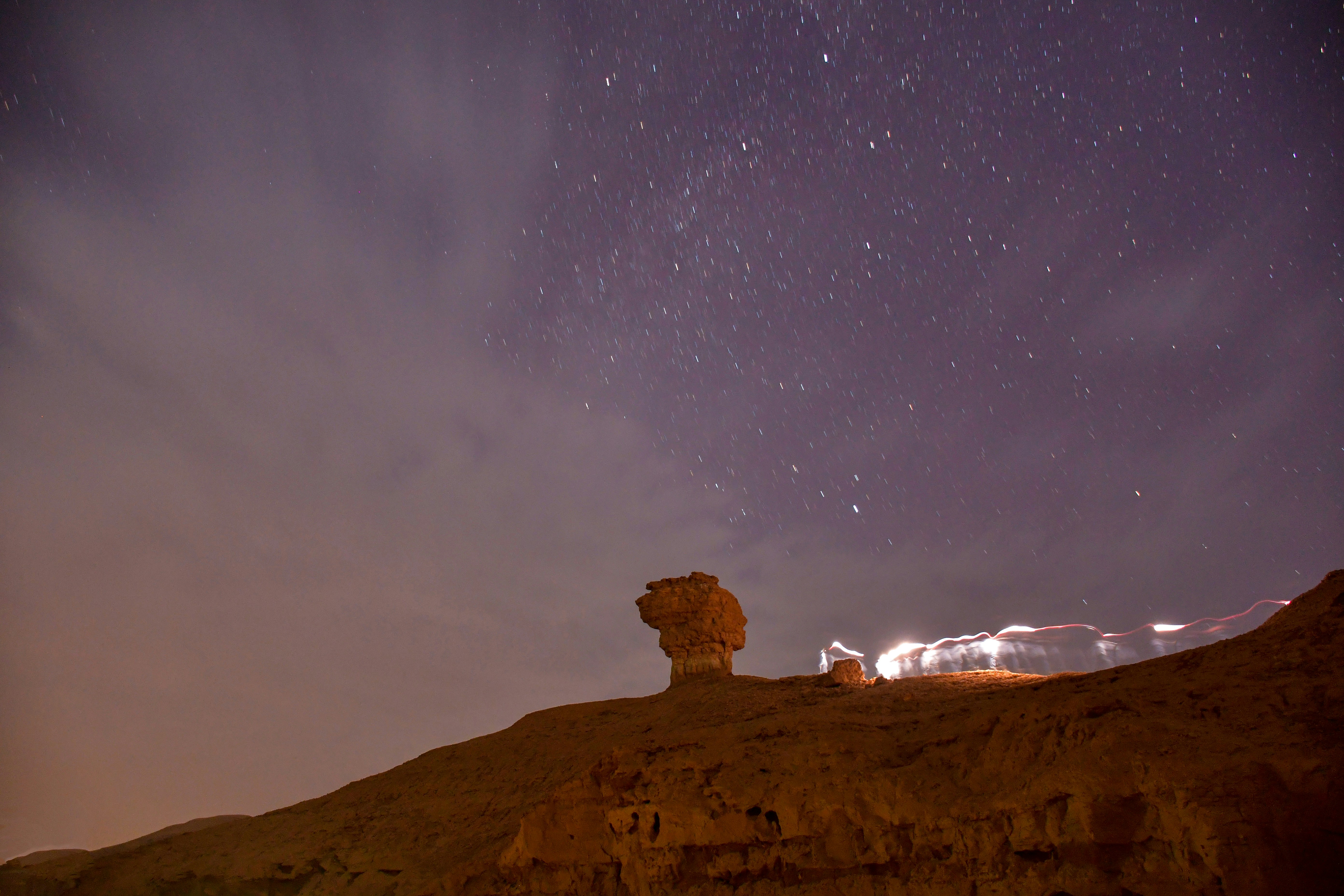 a rock formation in the desert under a night sky