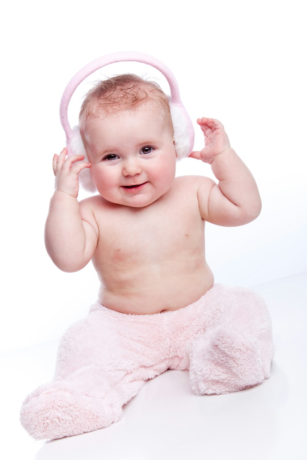 a baby wearing a pink outfit and a pair of headphones
