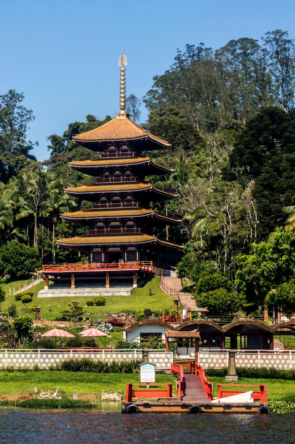 a tall building sitting on top of a lush green hillside