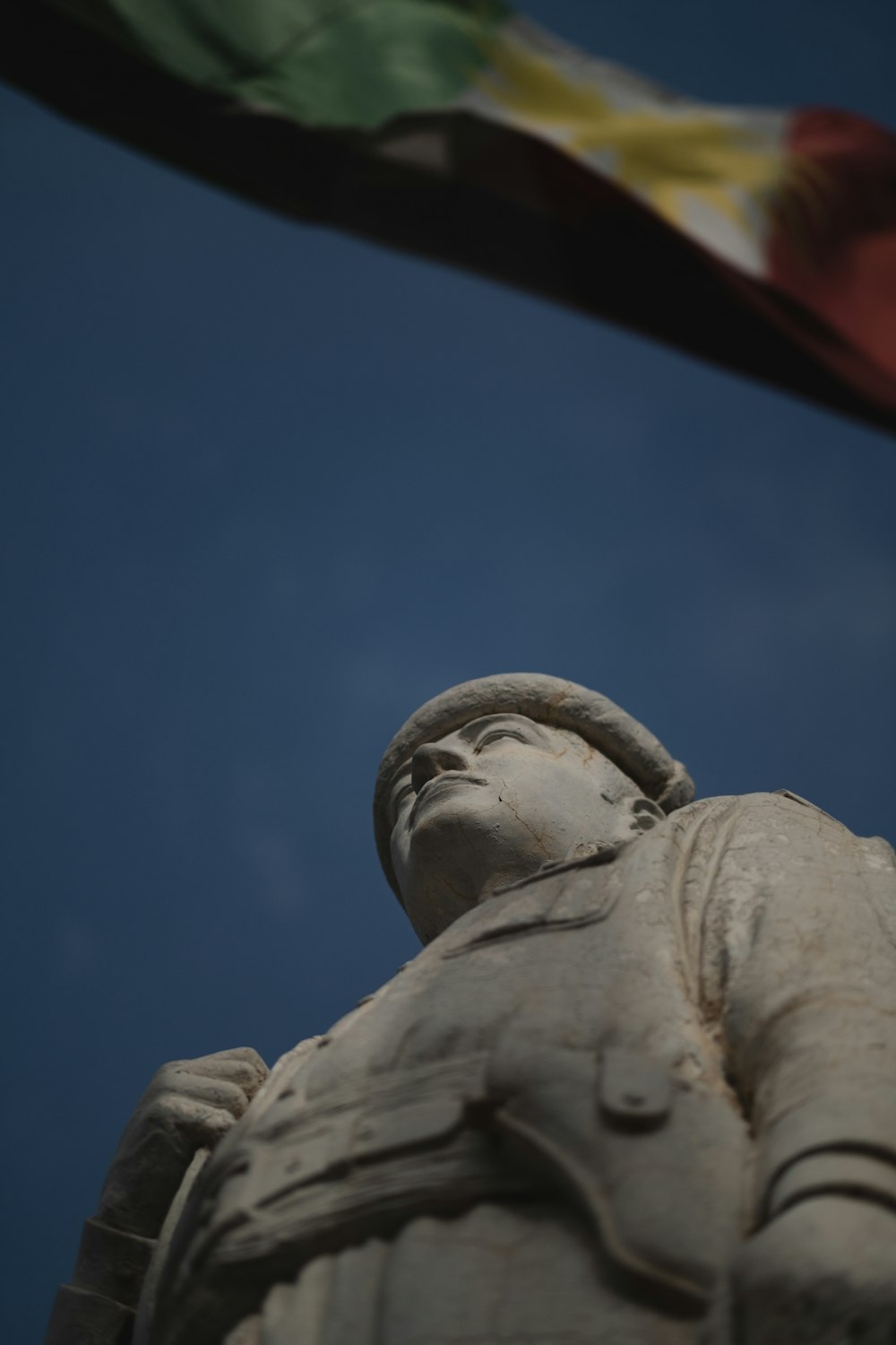 a statue with a flag flying in the background