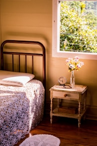 a bedroom with a bed, nightstand and window