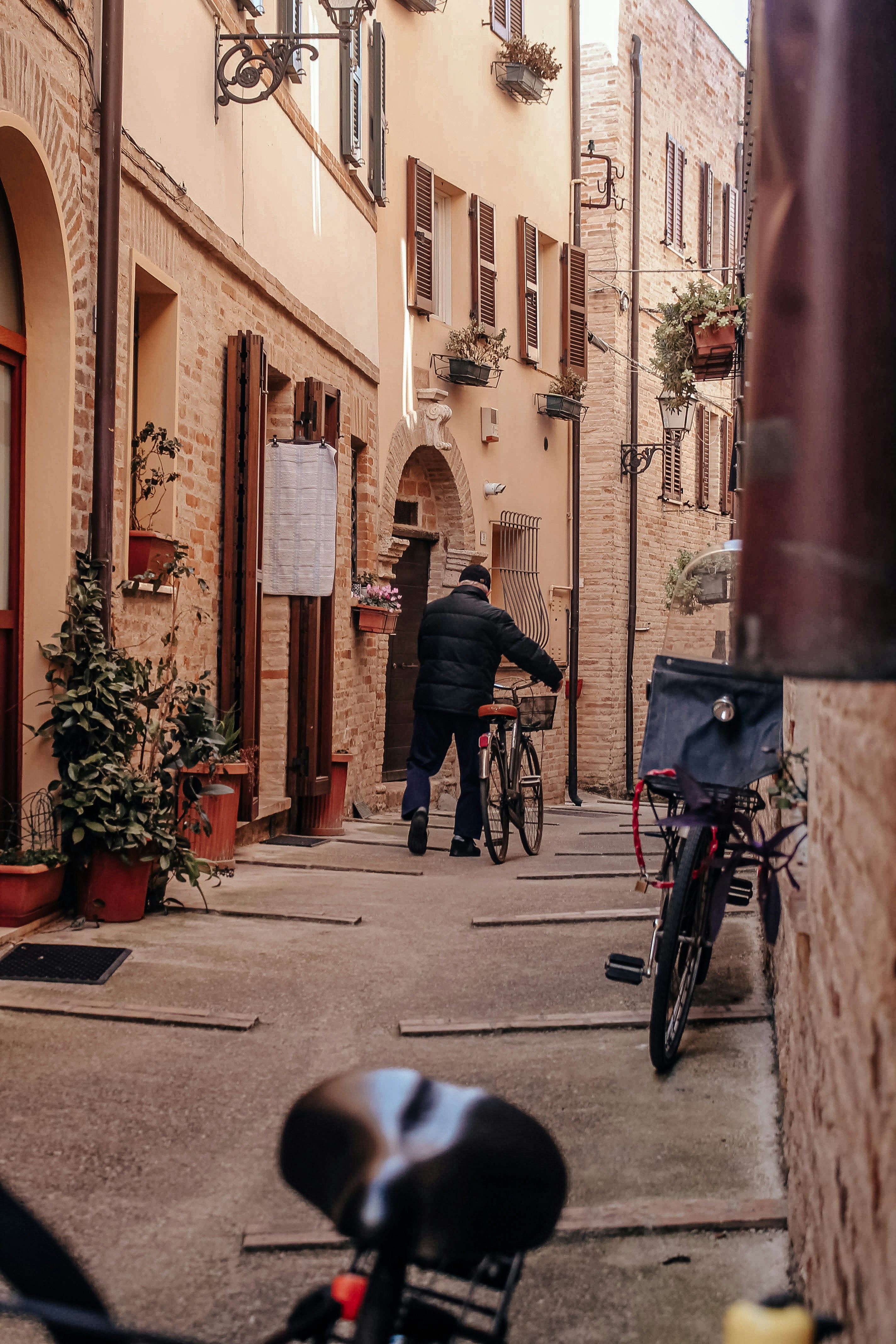 a man walking down a street next to a bike