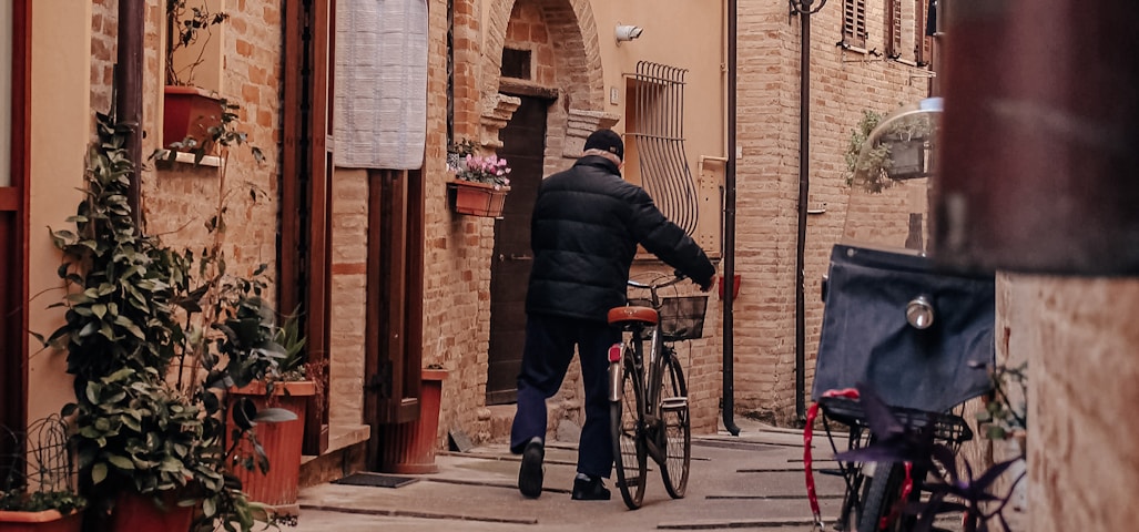 a man walking down a street next to a bike