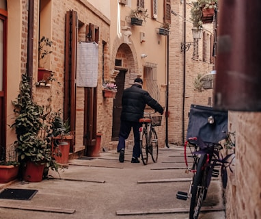 a man walking down a street next to a bike