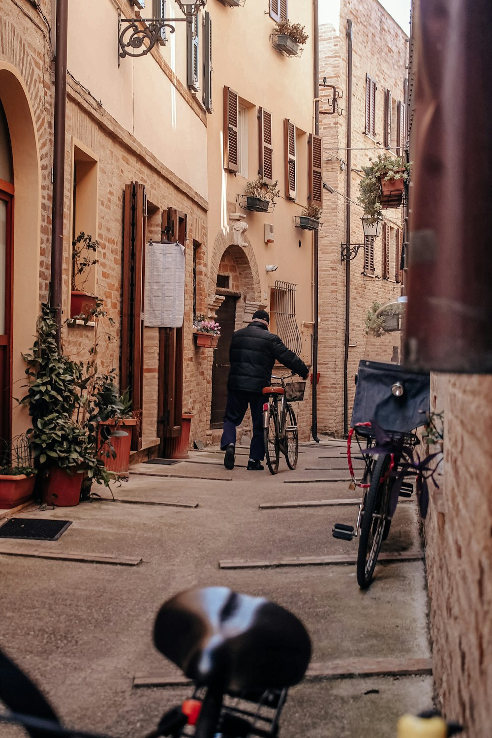 a man walking down a street next to a bike