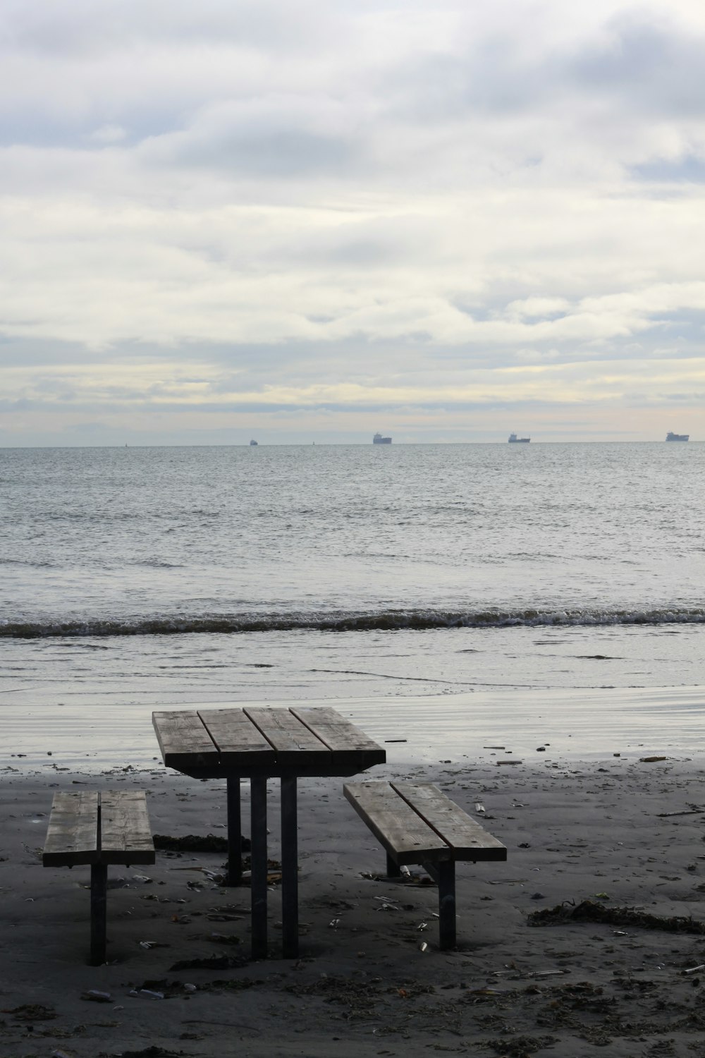 a couple of benches sitting on top of a sandy beach