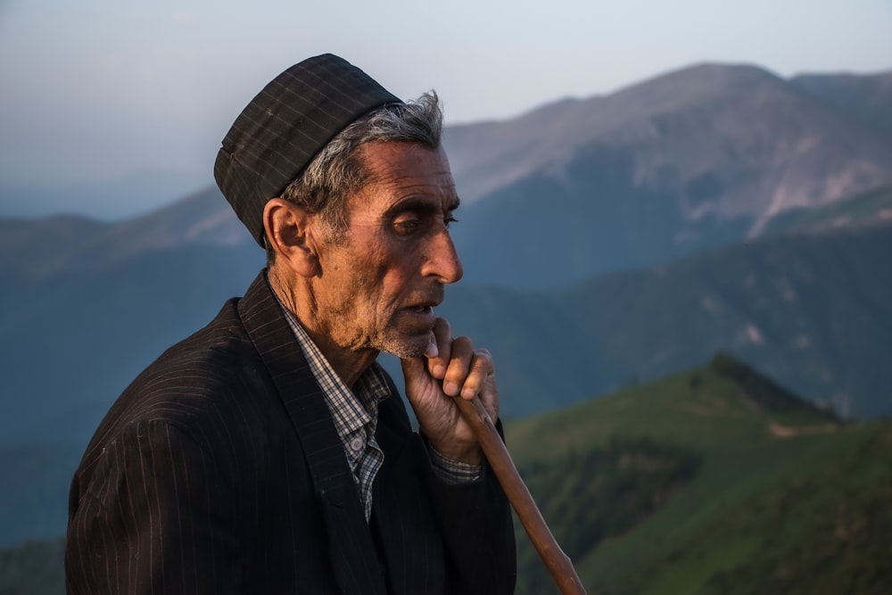 a man with a stick in his hand on top of a mountain