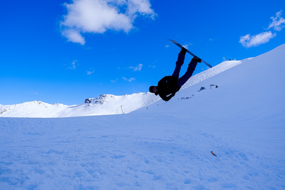 Un uomo che vola nell'aria mentre cavalca uno snowboard