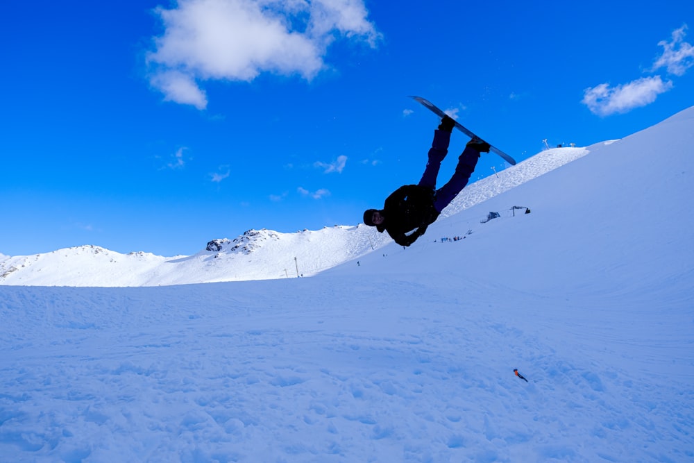 a man flying through the air while riding a snowboard