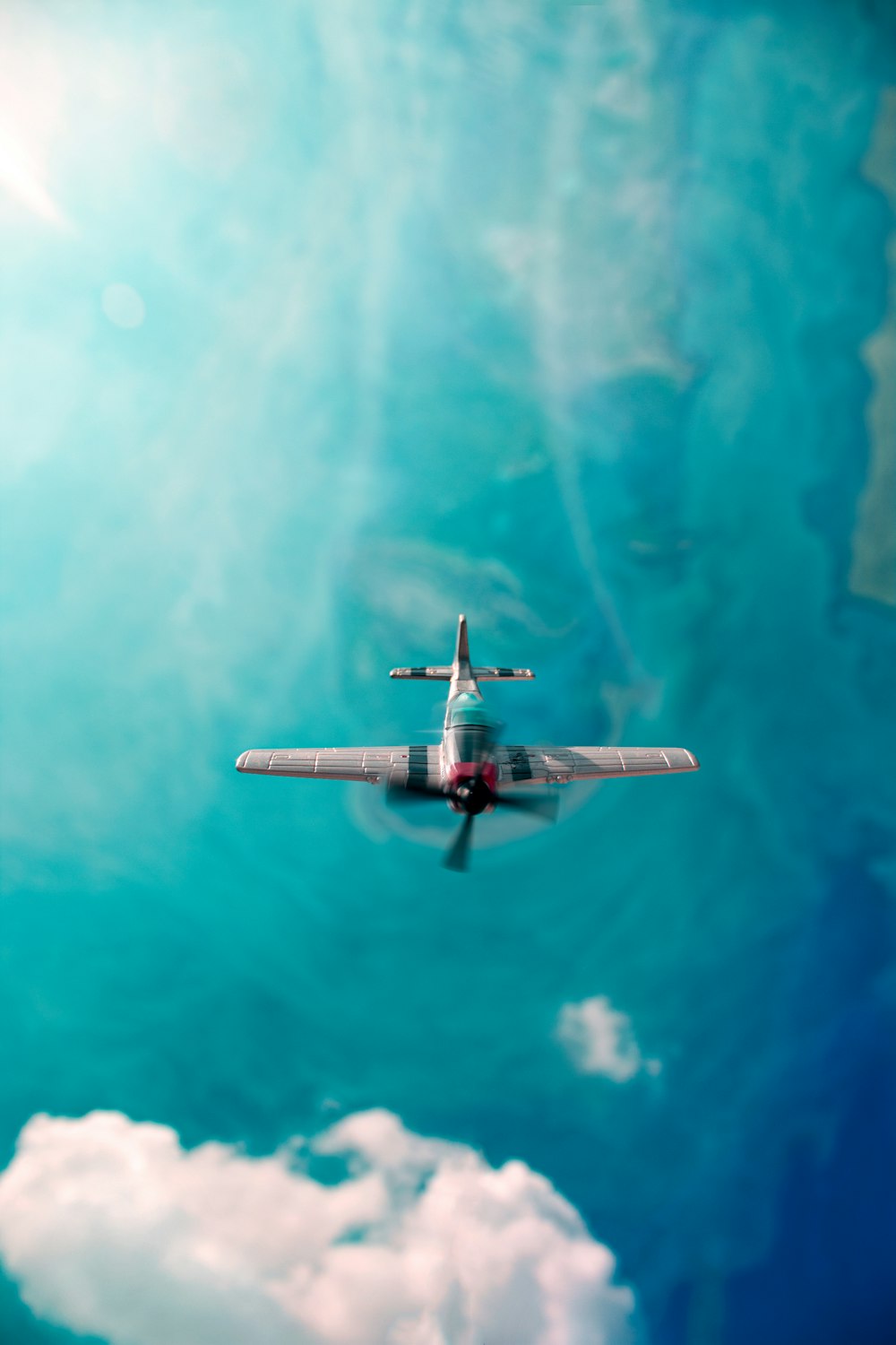 an airplane flying through a blue cloudy sky