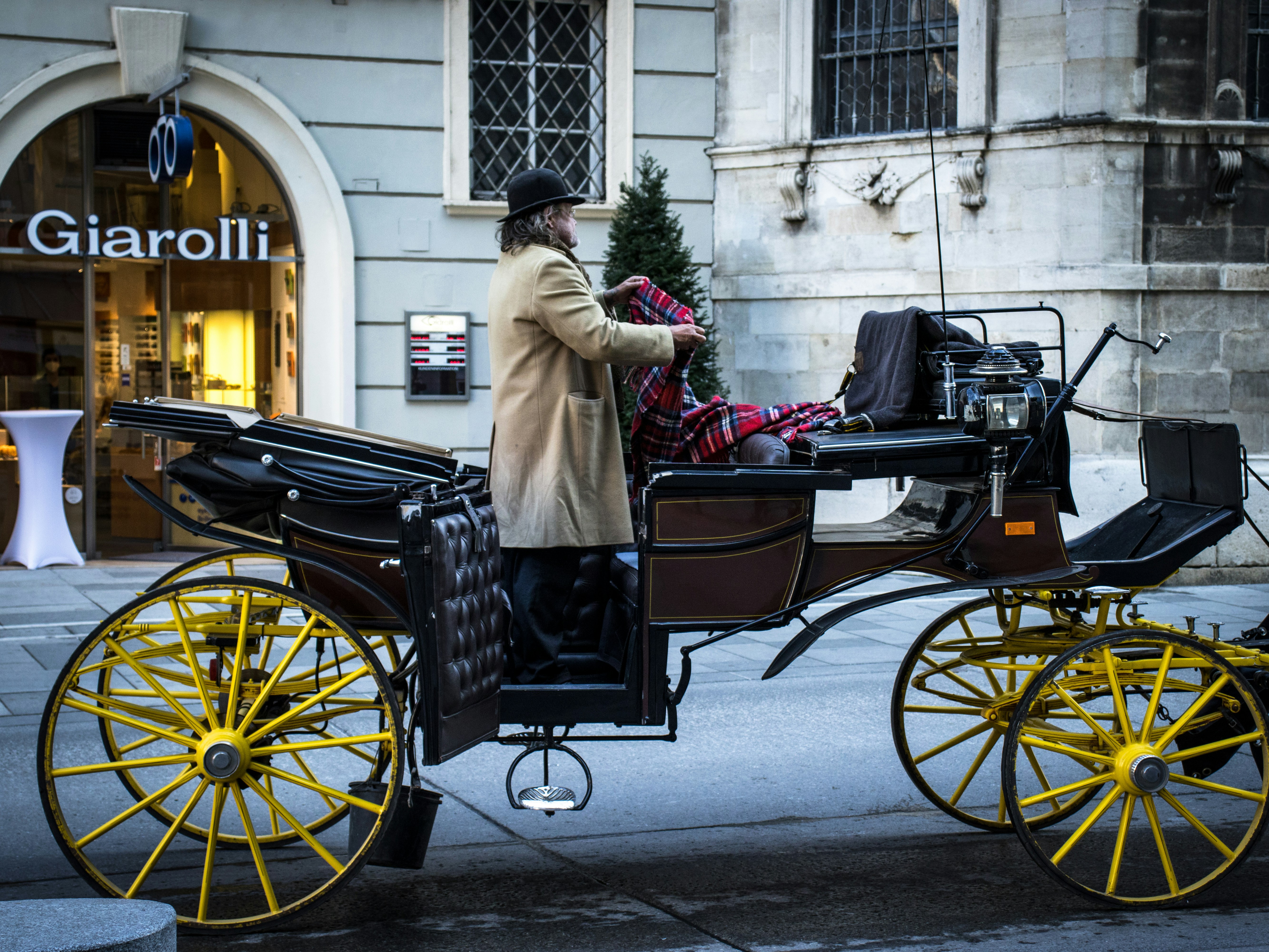 a man sitting in a horse drawn carriage