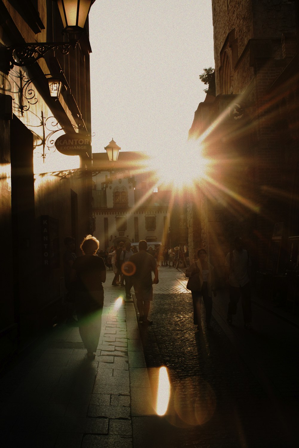 a group of people walking down a street next to tall buildings